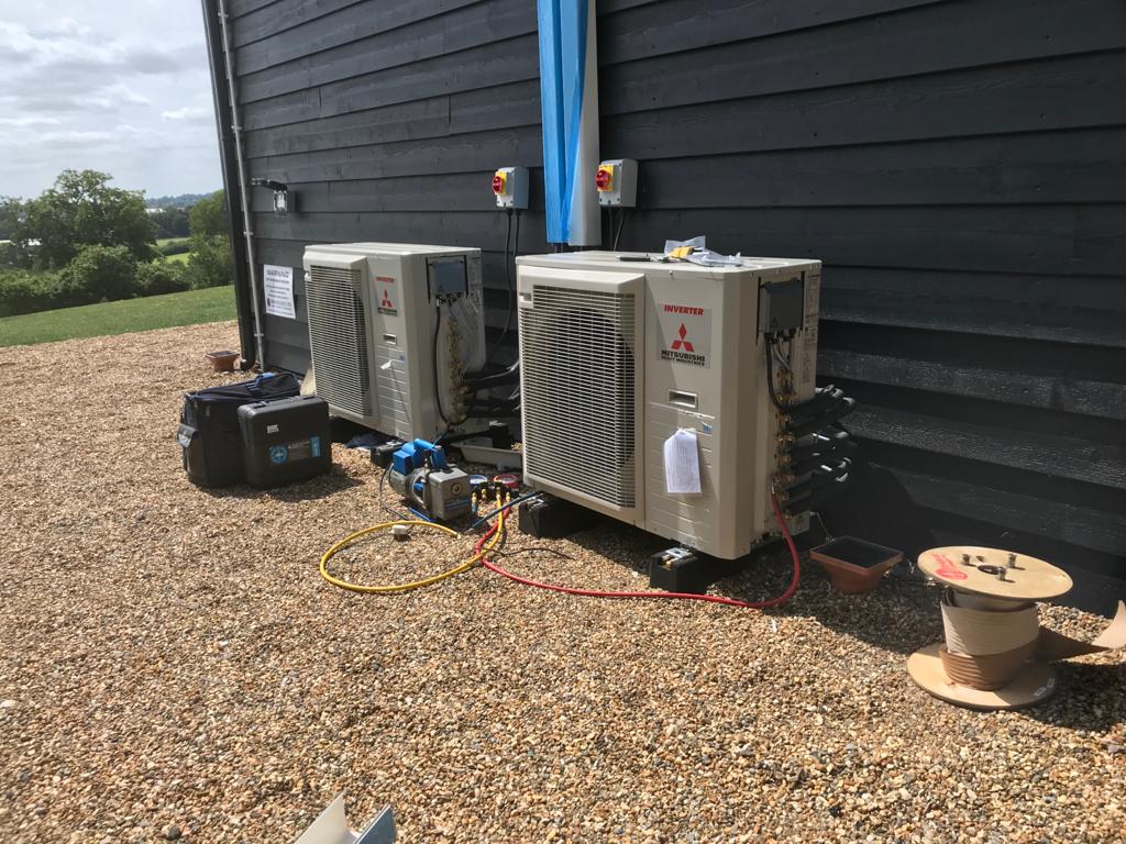 Two outdoor air conditioning units installed with professional tools and vacuum pump
