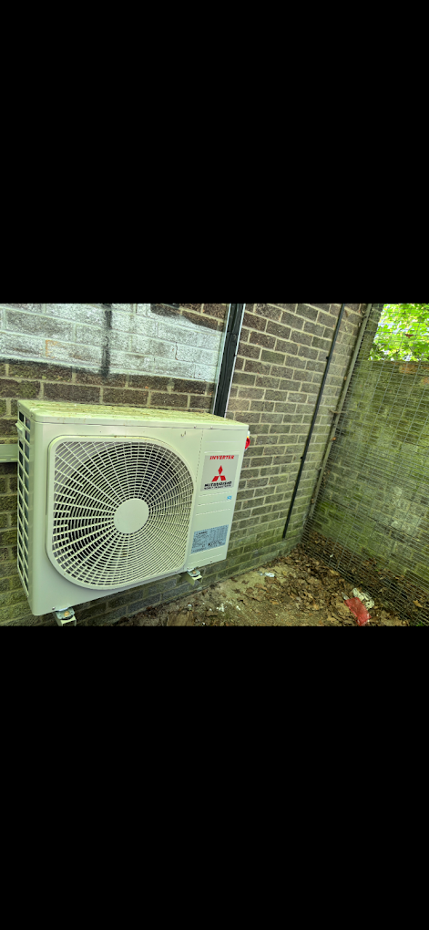Outdoor air conditioning unit mounted on a brick exterior wall