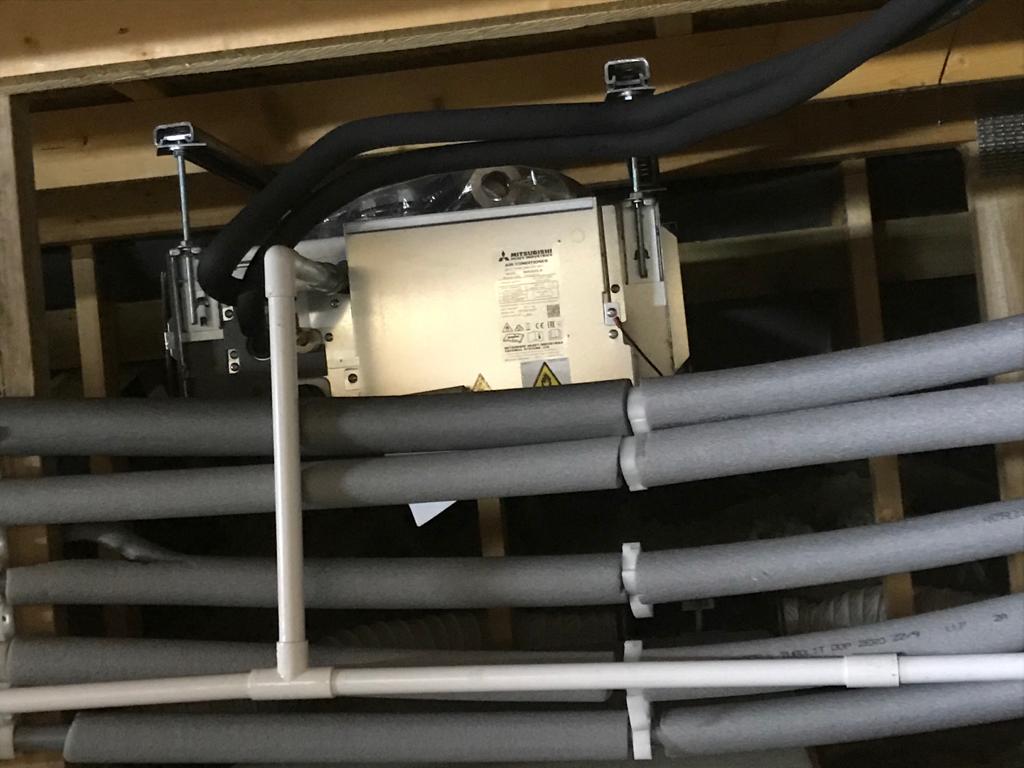 Air conditioning unit installed in a ceiling cavity with insulated pipework
